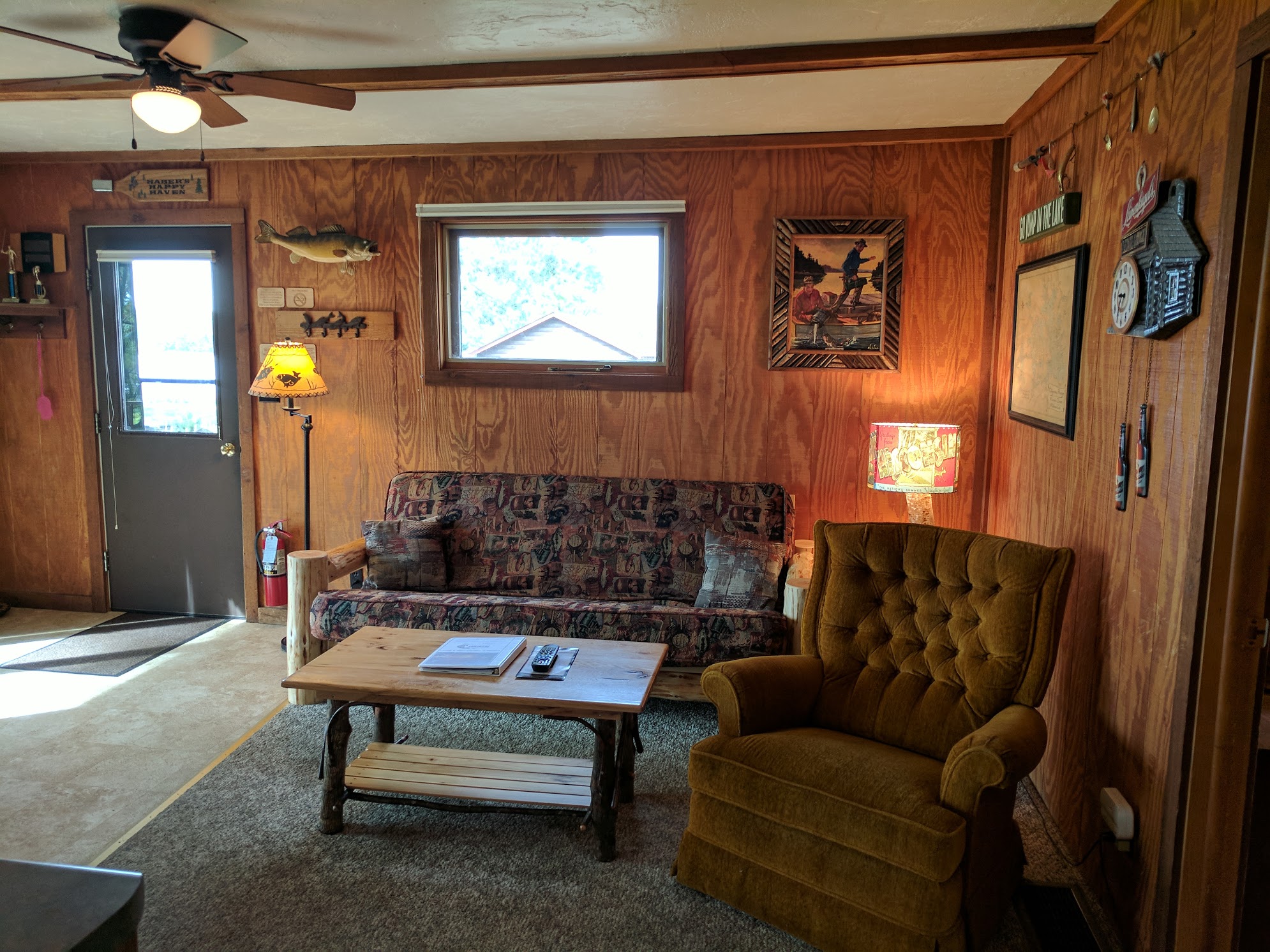A cozy lobby with a sofa, chair, coffee table, and lamp.